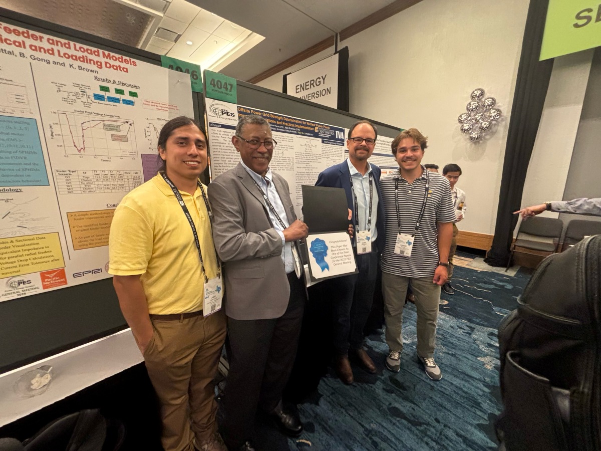 Julio Gonzalez, left, Dr. Abdel Karrar, Mark Bowman and Andrew Adams stand with their IEEE Prize Paper award in front of their conference poster.
