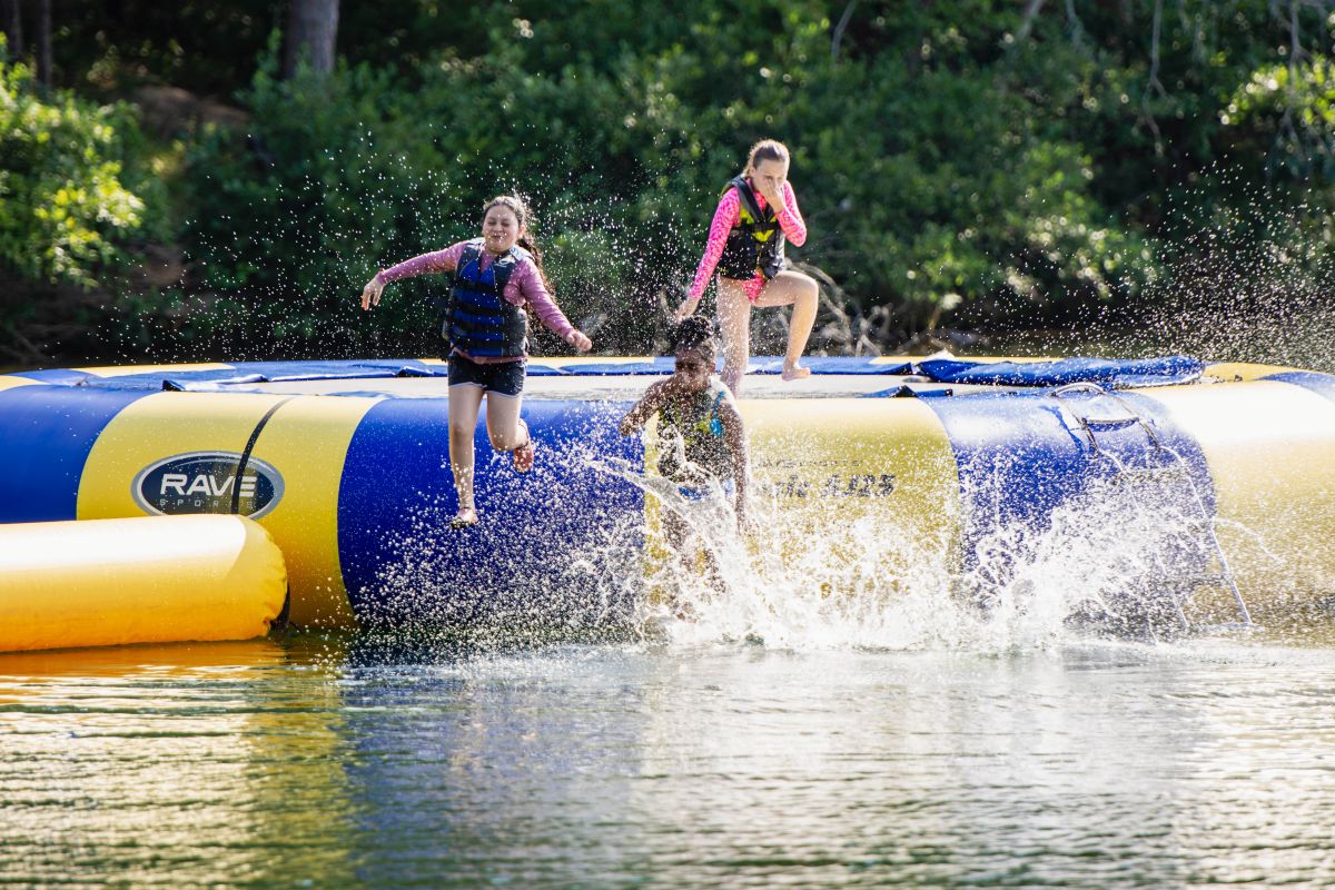 3 girls jumping into the water at YMCA Camp Ocoee