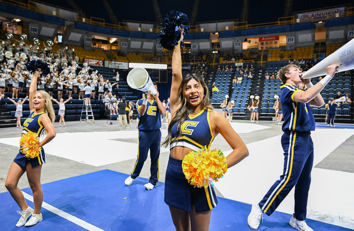 Cheerleaders do a cheer on the McKenzie Arena floor