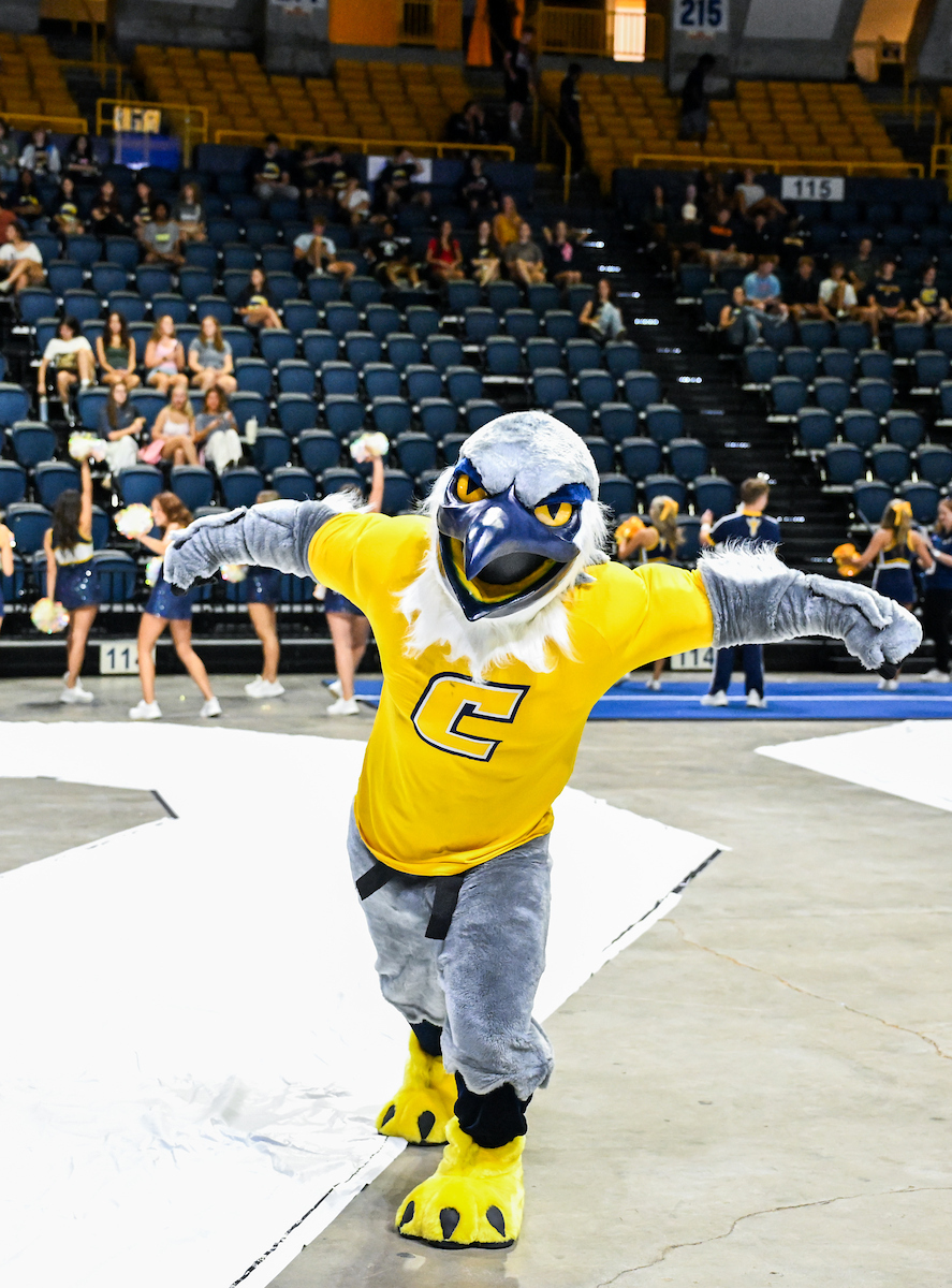 Scrappy the mascot doing a dance move on the McKenzie Arena floor