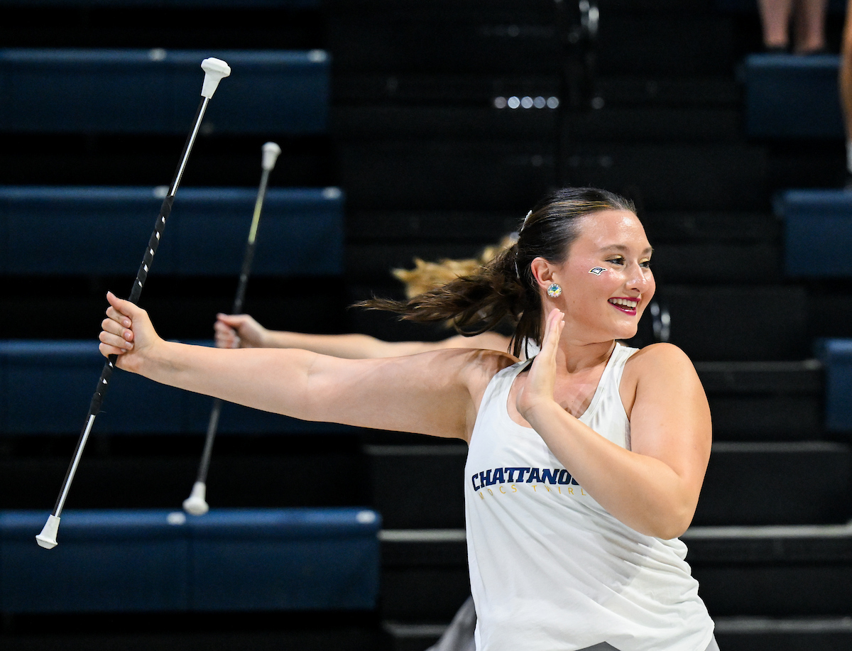 Dancers smile and hold batons in McKenzie Arena