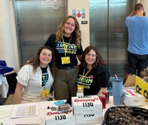 Three colunteers with the Chattanooga Autism Center smile for a picture