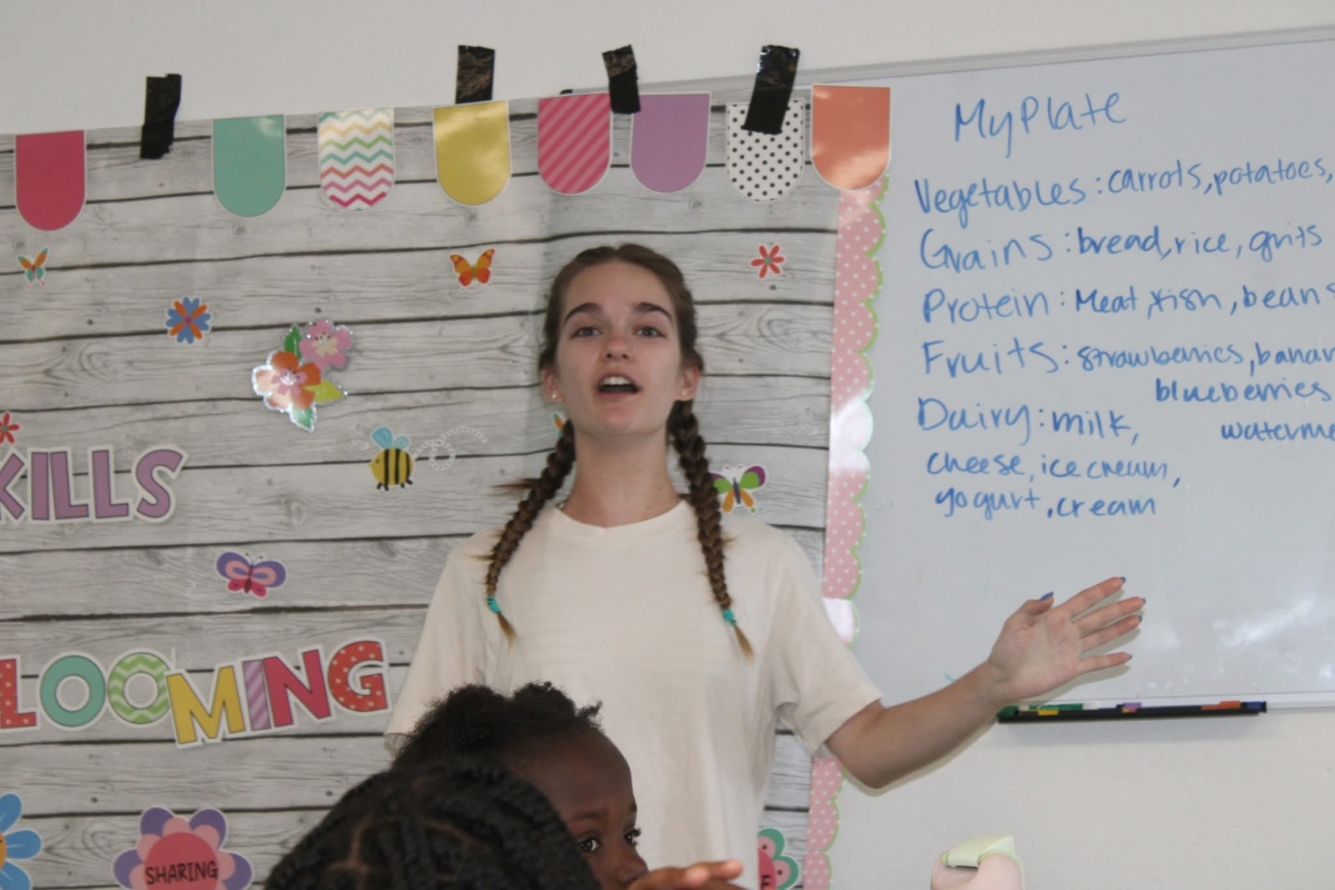 Gillian Morton stands in front of a white board at the front of a classroom
