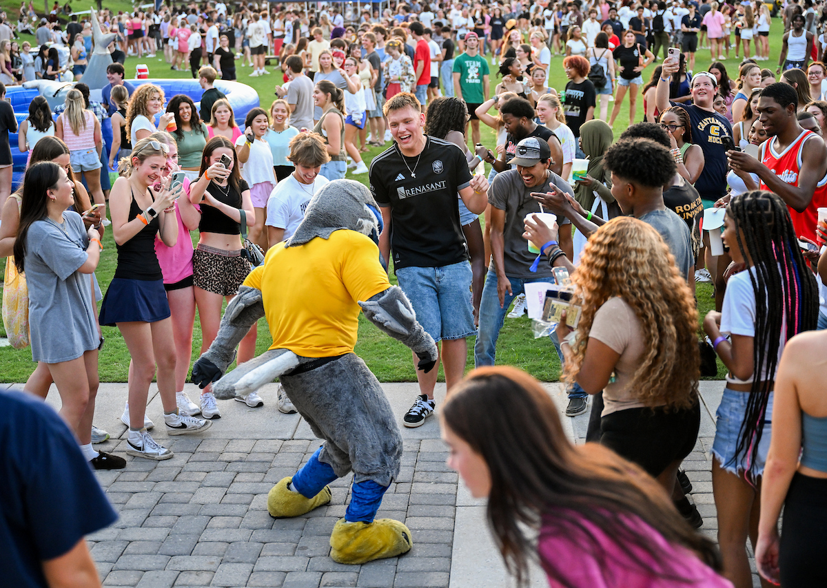 Scrappy the mascot dances in front of a crowd of students at Welcome Week.