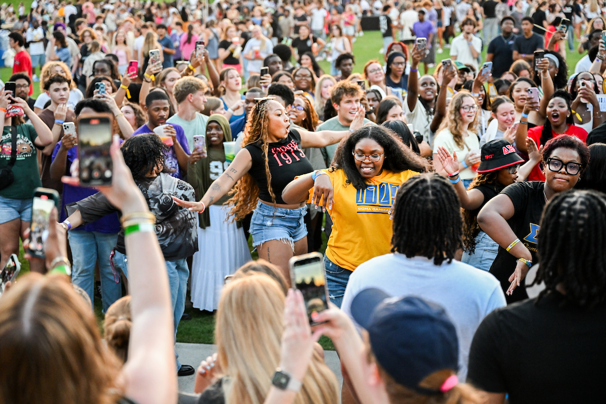 Students cheer and record on their phones while others dance at Welcome Week.