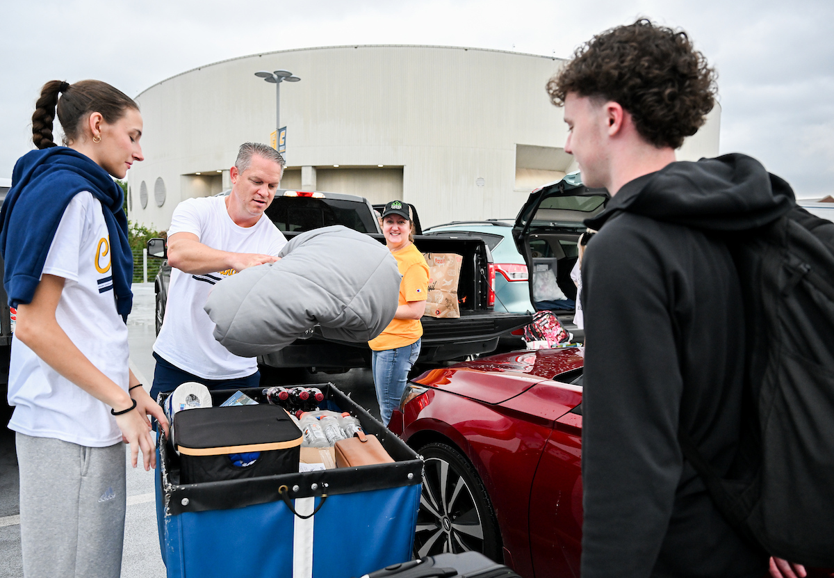 Volunteers work to help students and their families bring items into housing.