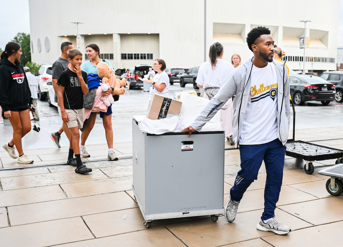 Volunteers work to help students and their families bring items into housing.