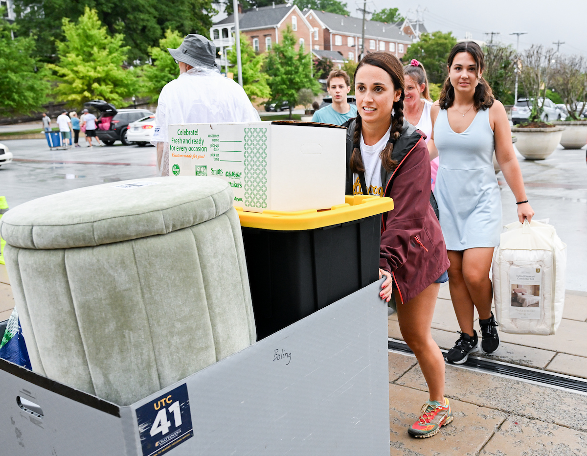 Volunteers work to help students and their families bring items into housing.