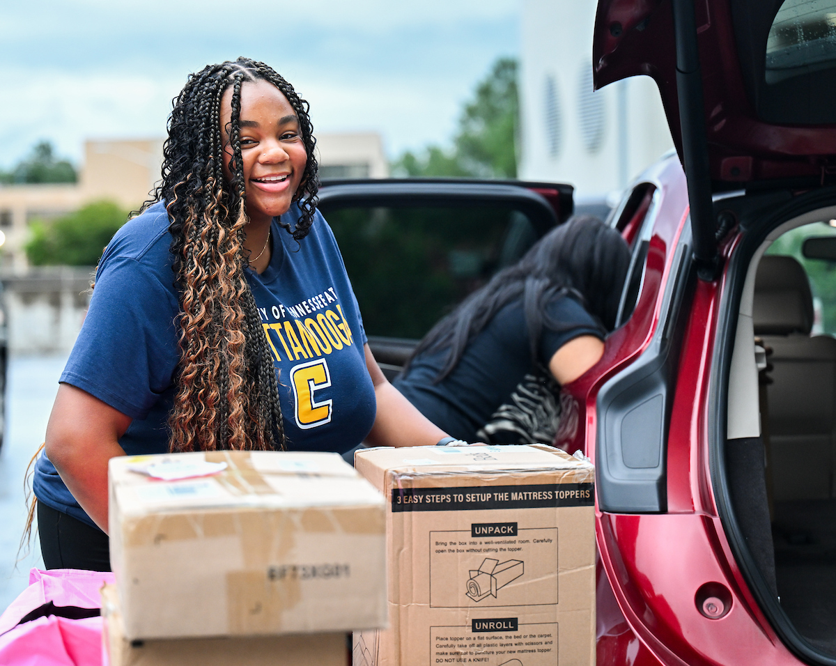 A student moves her belongings into West Campus Housing.