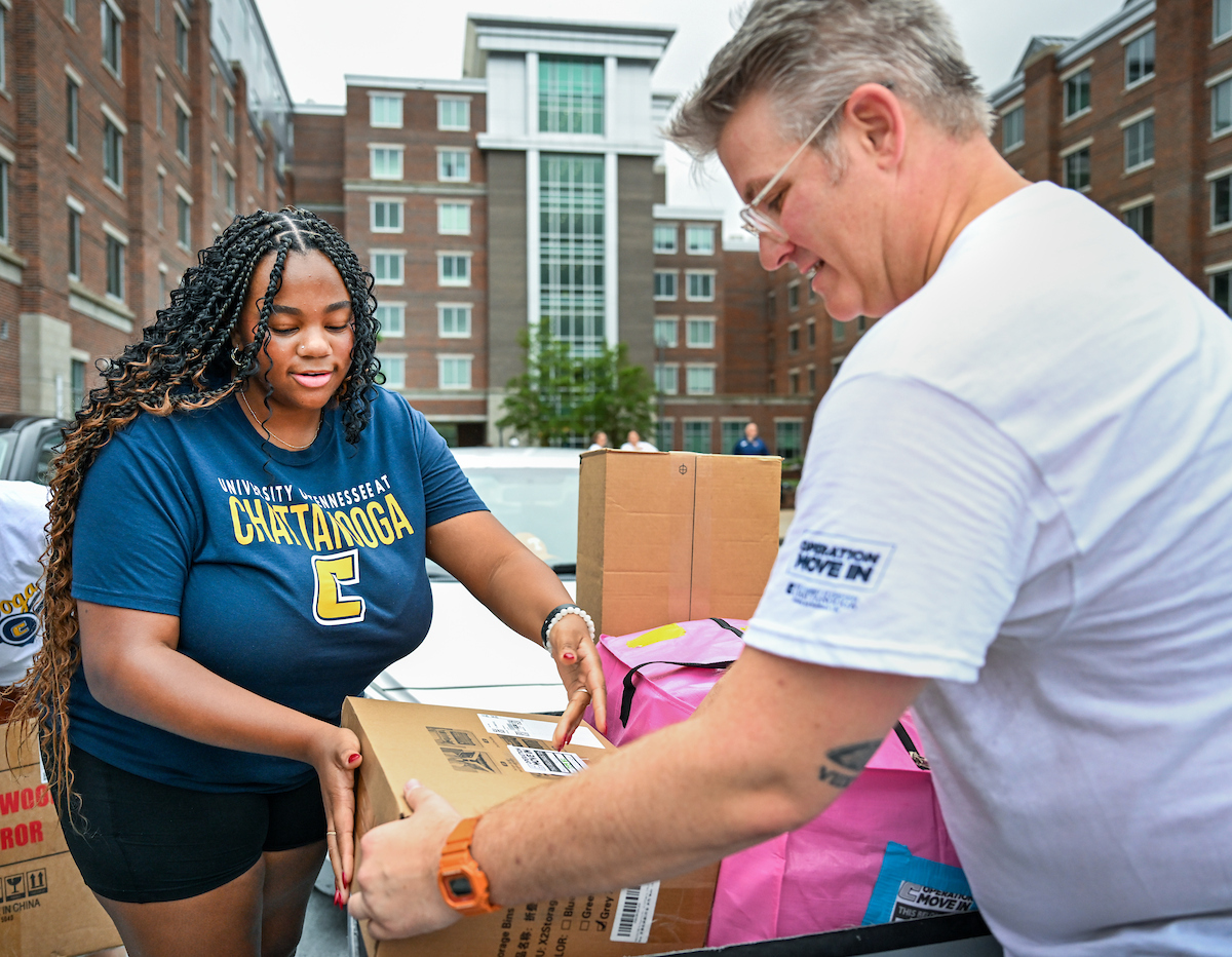 Volunteers work to help students and their families bring items into housing.