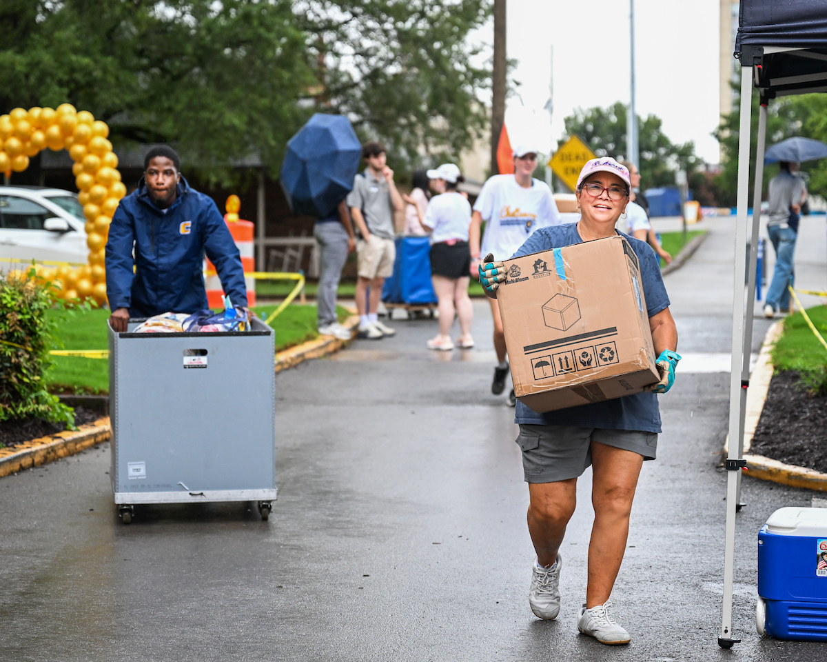 Volunteers work to help students and their families bring items into housing.