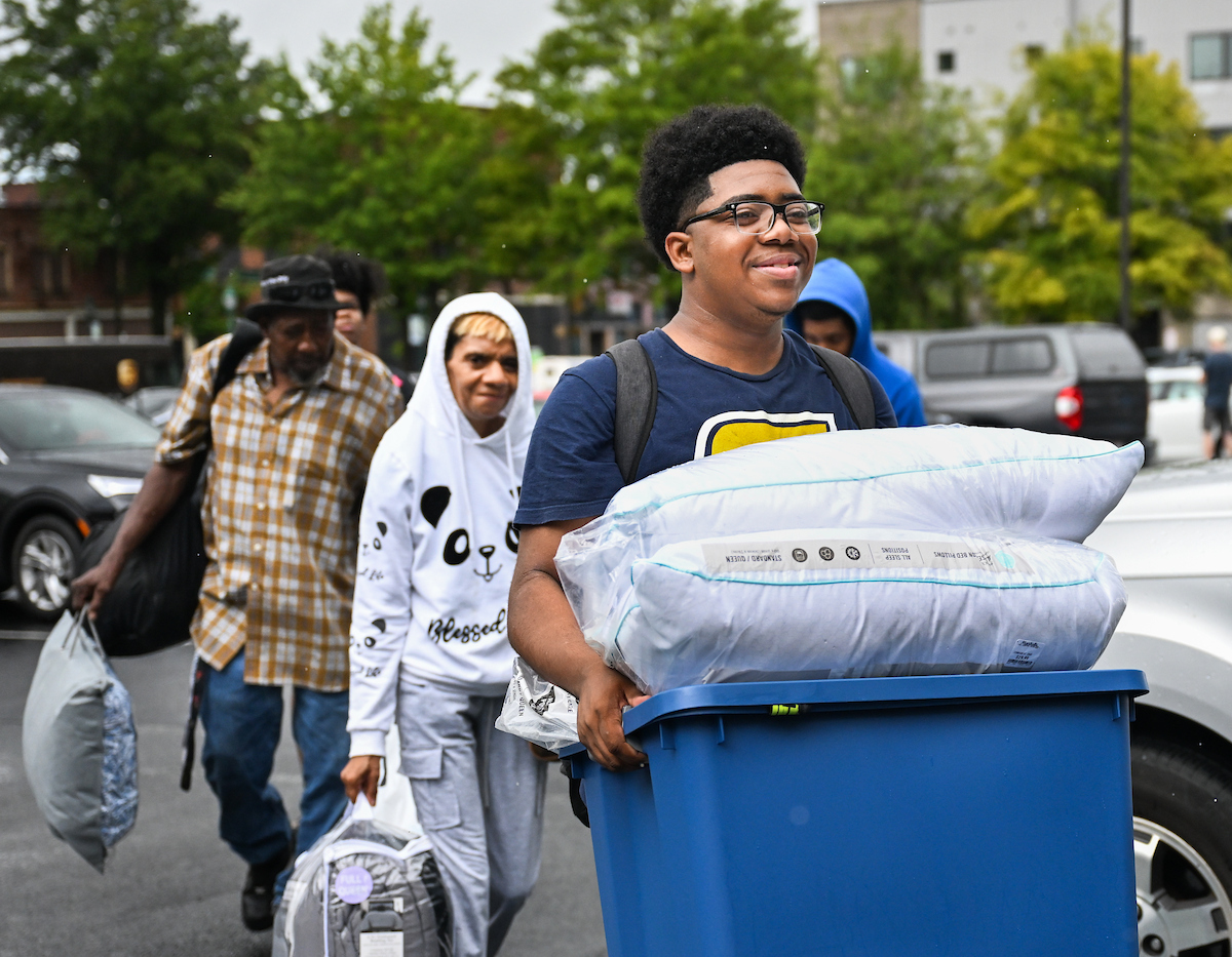 Volunteers work to help students and their families bring items into housing.