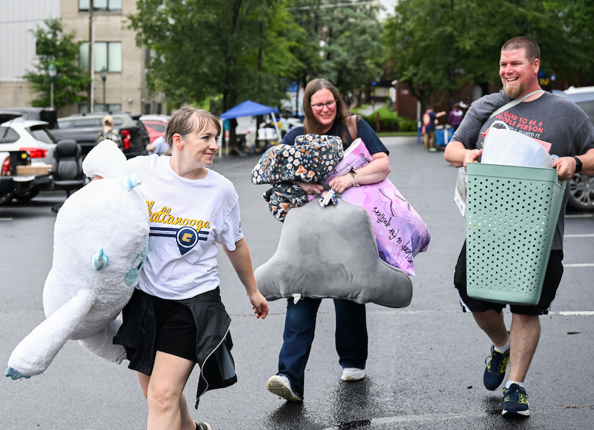 Volunteers work to help students and their families bring items into housing.