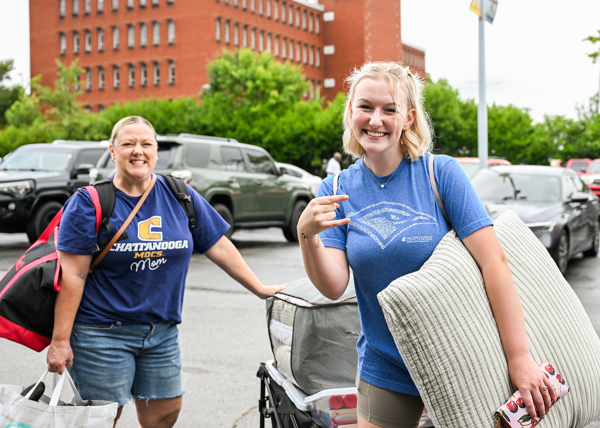 Volunteers work to help students and their families bring items into housing.