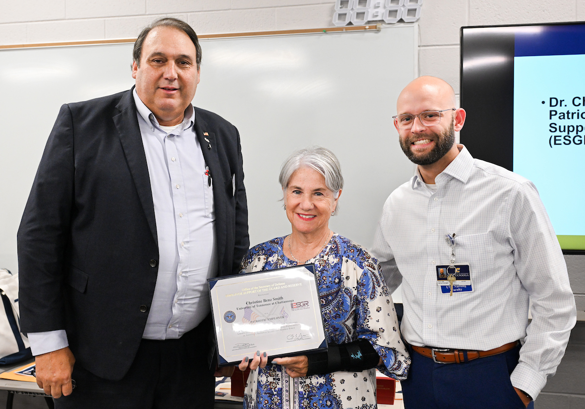 Retired Army Lt. Col. Scott Hardin presents Dr. Chris Smith with the Patriot Award. Smith was nominated for the award by Terry Ellis, right, a member of the School of Nursing faculty and a first lieutenant in the Army National Guard.