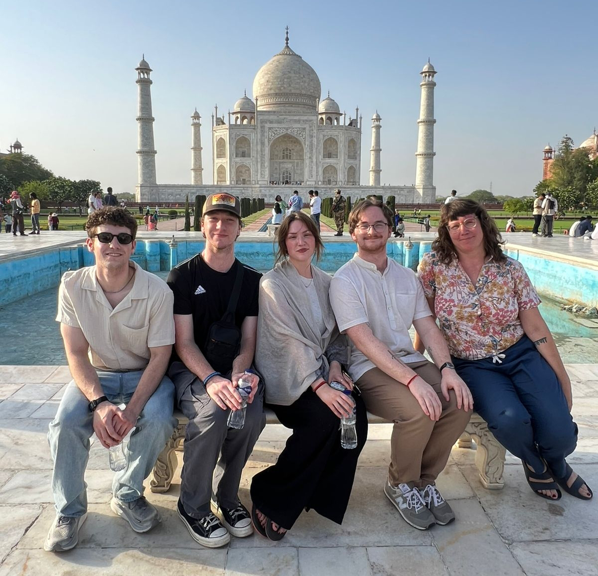 Four UTC students and Associate Professor Jaclyn Michaels sitting in front of the Taj Mahal in India.