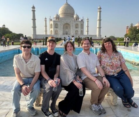 Four UTC students and Associate Professor Jaclyn Michaels sitting in front of the Taj Mahal in India.