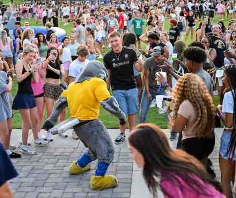 Scrappy the mascot dances in front of a crowd of students at Welcome Week.