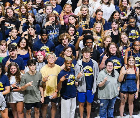 A flock of UTC students flashing the Power C at Convocation 2025