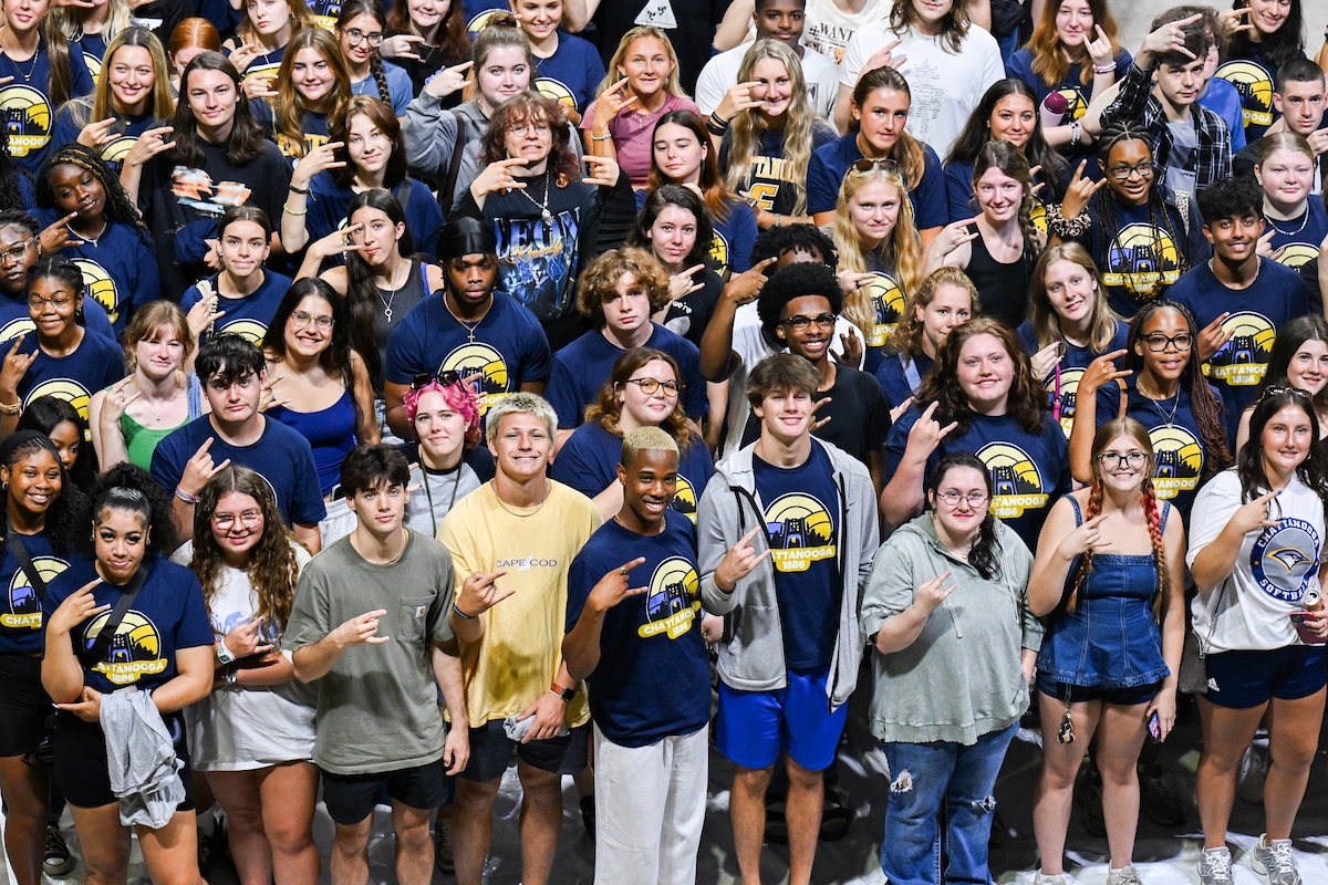 A flock of UTC students flashing the Power C at Convocation 2025