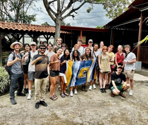 A group of UTC students standing with a Power C flag during a study abroad trip to Costa Rica