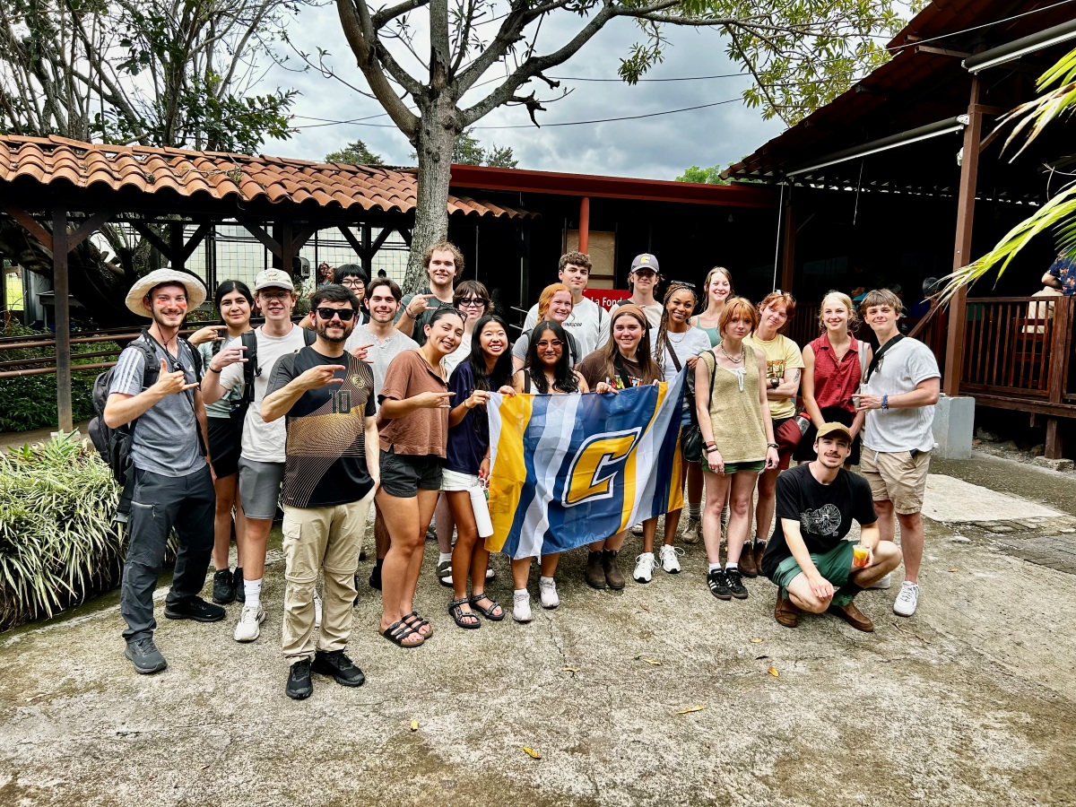 Group of UTC students standing with Power C flag during a study abroad trip to Costa Rica