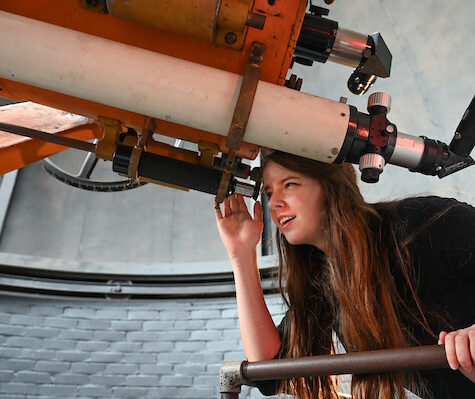 Picture of a student looking into a telescope at the Clarence T. Jones Observatory