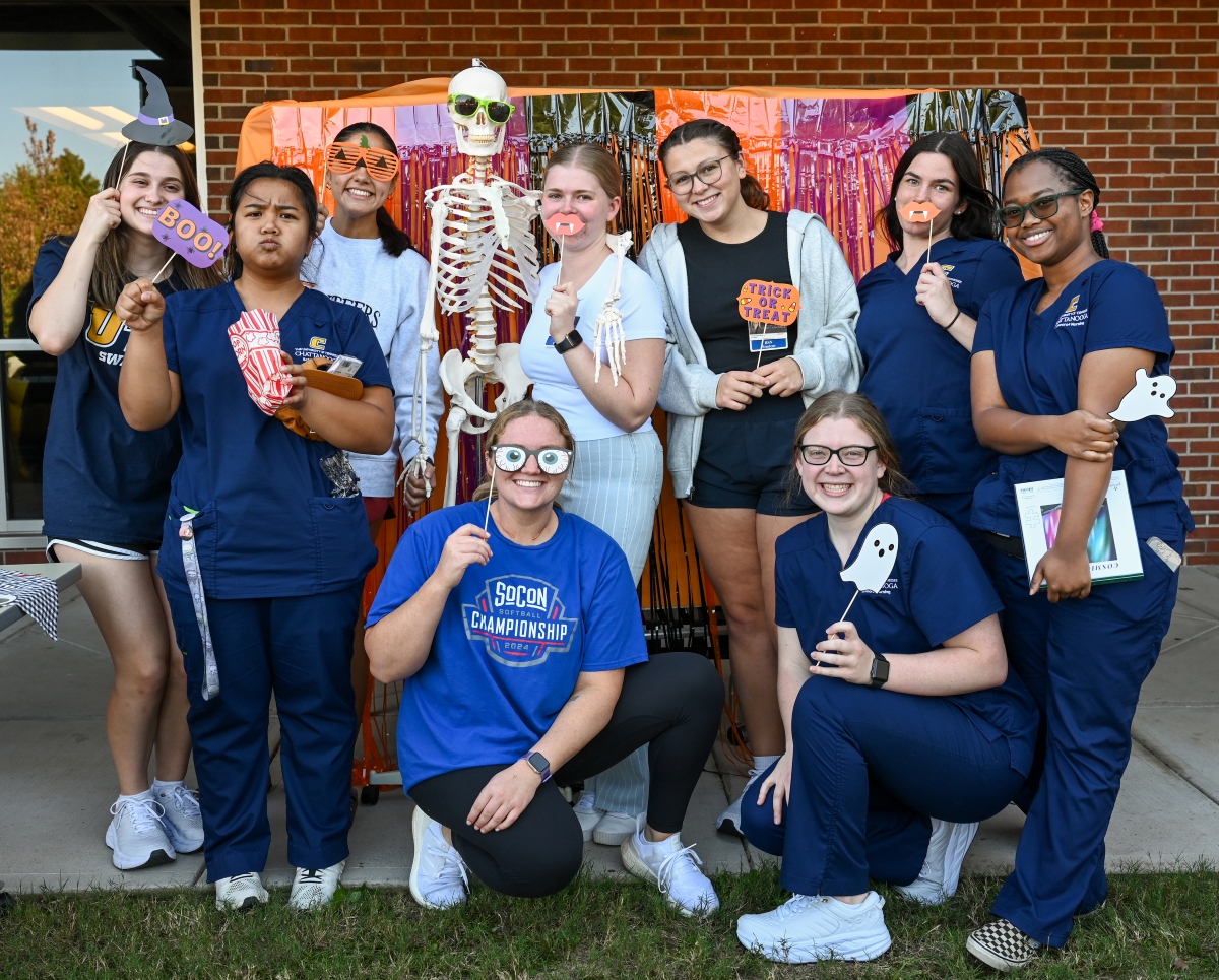Nursing students with a skeleton and props during Nursing Fall Festival