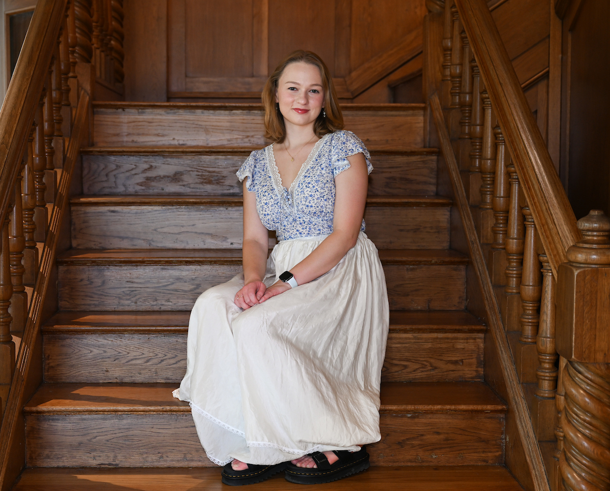 Sofiia Skrypkar sits on wooden steps in the Guerry Center.