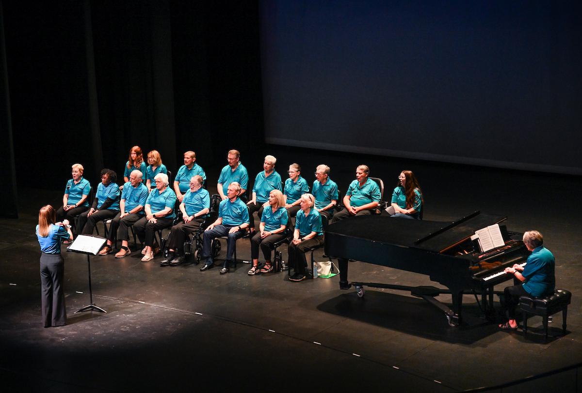 Members of the Trembling Troubadours sitting in chairs on the Roland Hayes Concert Hall stage