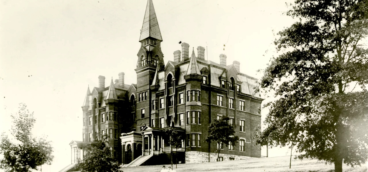 Black-and-white photo showing the exterior of Old Main on the University campus circa 1900s. 