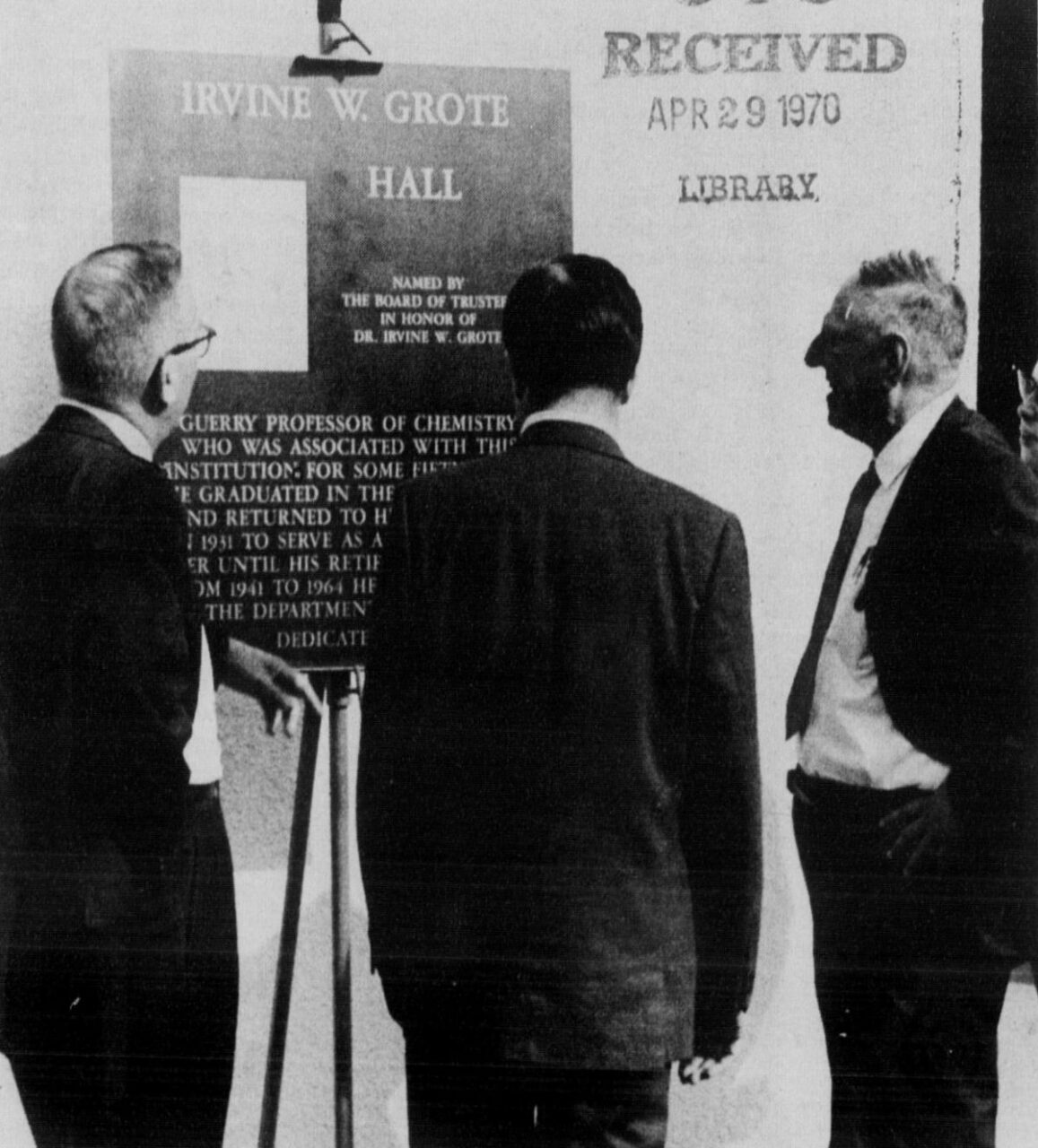 Black-and-white photograph of Grote (right) and the Irvine W. Grote Hall dedicatory plaque