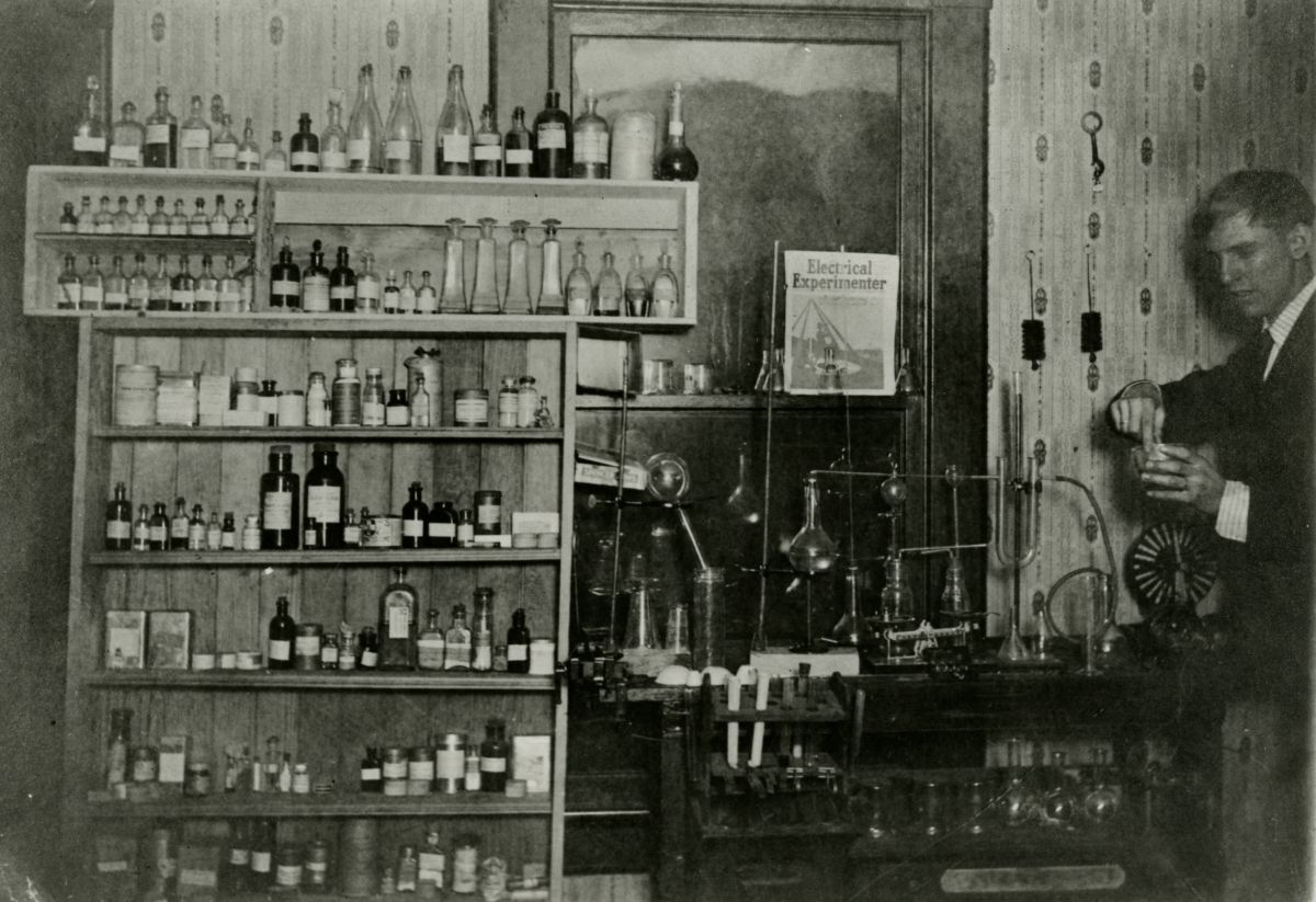 Black-and-white photograph of a young Irvine W. Grote preparing a chemistry experiment.