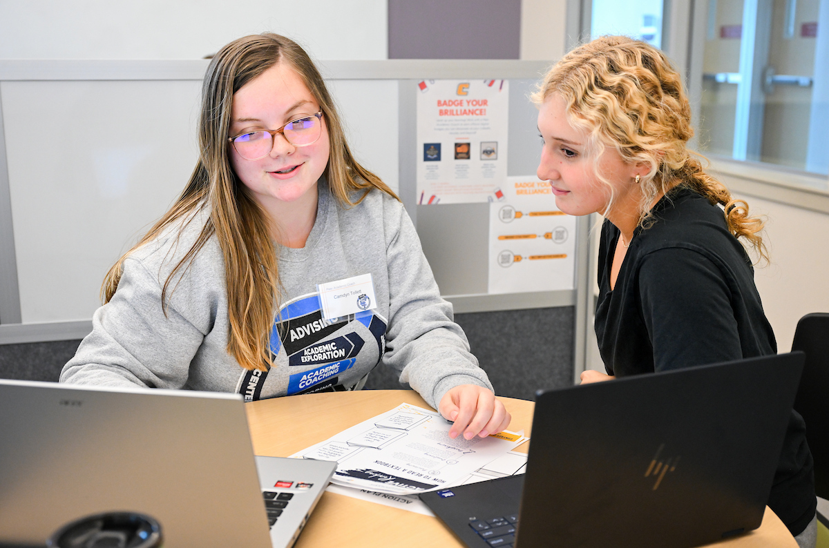 Two students look at a laptop during an advising visit