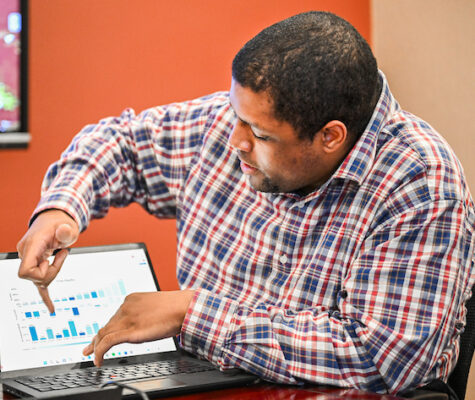 Mychael Allen-Fennessee displays the research he's been doing, showing off a bar graph on his laptop