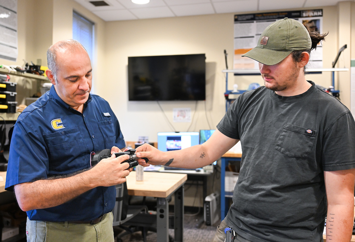 Erkan Kaplanoglu and graduate student Chase Guttu (wearing hat) demonstrate their device
