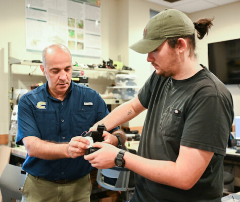 Erkan Kaplanoglu and graduate student Chase Guttu (wearing hat) demonstrate their device