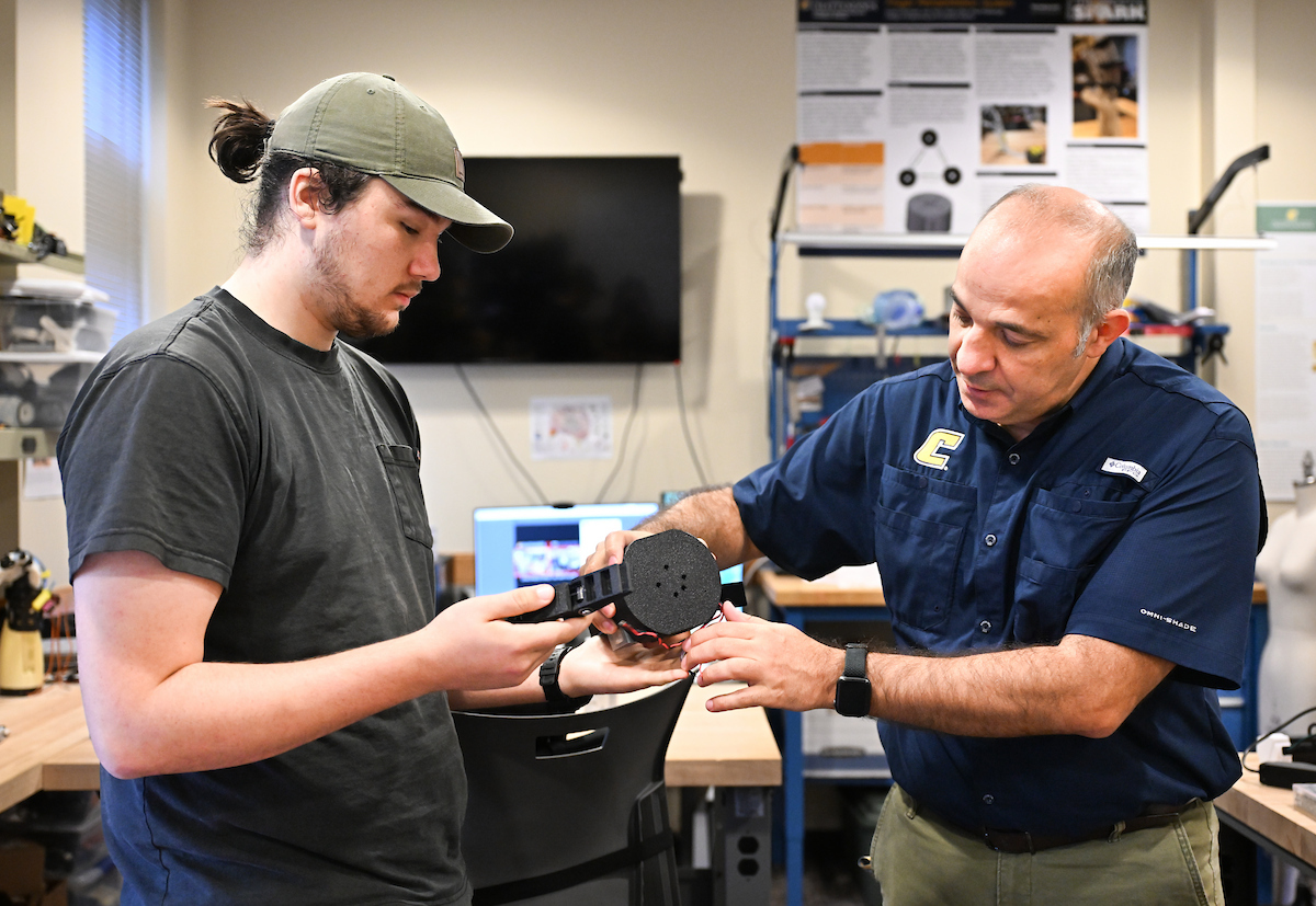 Erkan Kaplanoglu and graduate student Chase Guttu (wearing hat) demonstrate their device