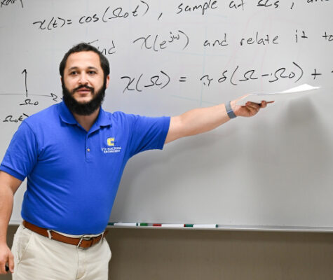 Joshua Tyler stands in front of a greaseboard in his electrical engineering class