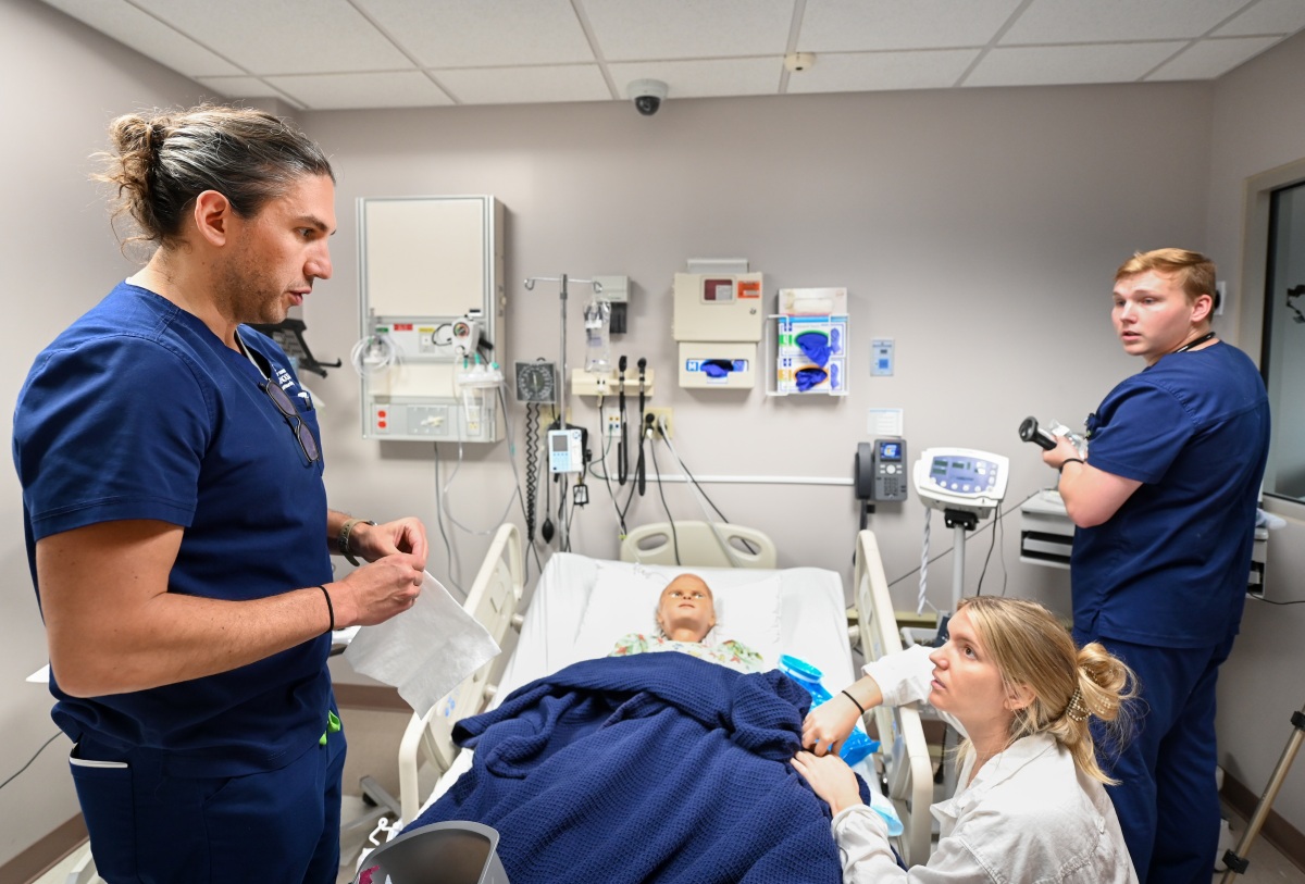 A nursing skills drill with nursing students practicing their skills on a mannikin