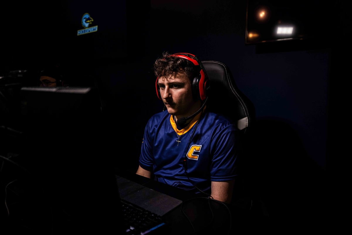Chase Daffron wearing headphones and sitting at a video game console in the UTC Esports Complex