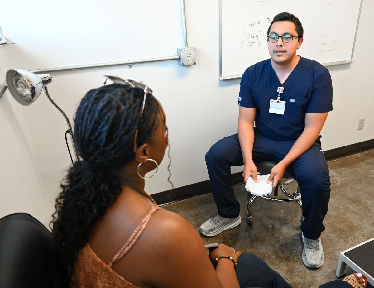 A DNP student practices his craft by talking to an actor simulating a patient